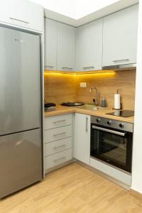 a kitchen with white cabinets and a stainless steel refrigerator at DeKolomvou in Thessaloniki