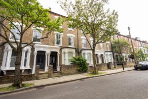 a row of brick houses on a city street at Elegant 1BR Flat l Jacuzzi l Prime London Location in London