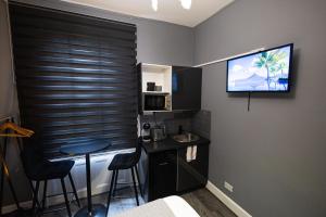 a small room with a sink and a television on the wall at Elegant 1BR Flat l Jacuzzi l Prime London Location in London