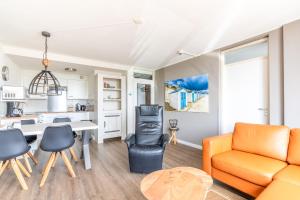 ein Wohnzimmer mit einem Sofa und einem Tisch in der Unterkunft Appartementencomplex Juliana 72 in De Koog