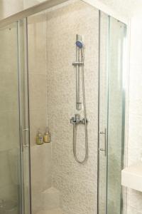 a shower with a glass door and a shower constructorangering at DeKolomvou in Thessaloniki