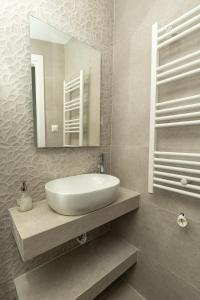 bagno con lavandino bianco e specchio di DeKolomvou a Salonicco