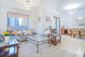 ein Wohnzimmer mit einem Sofa und einem Tisch in der Unterkunft JBR The walk Rimal 6 - 3 Bedroom plus maid 2m walking to beach in Dubai