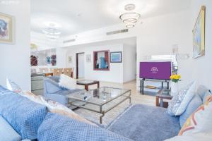 ein Wohnzimmer mit blauen Sofas und einem TV in der Unterkunft JBR The walk Rimal 6 - 3 Bedroom plus maid 2m walking to beach in Dubai