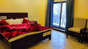 - une chambre avec un lit, une chaise et une fenêtre dans l'établissement The Lavish Inn, à Murree