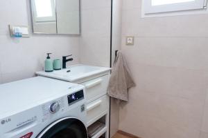 y baño con lavabo y lavadora. en Precioso ático en Valencia., en Valencia