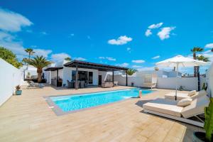 a backyard with a swimming pool and an umbrella at Beautiful Puerto Del Carmen Villa 3 Bedrooms Villa Crystal Private Pool & Close To Amenities Lanzarote in Tías