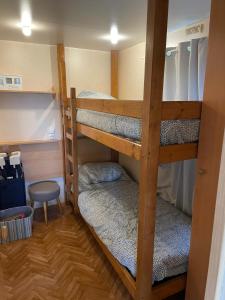 two bunk beds in a small room with a stool at Cabanon de la grenouille in Saint-Martin-des-Lais