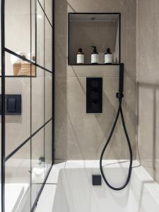 uma casa de banho com um chuveiro e uma porta de vidro em homely - North London Luxury Apartments Finchley em Finchley