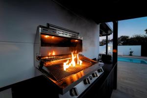 a grill with a fire in it on a patio at Beautiful Puerto Del Carmen Villa 3 Bedrooms Villa Crystal Private Pool & Close To Amenities Lanzarote in Tías