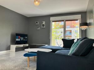 a living room with a blue couch and a table at Snowqueen Hotel Apartment Paris-Disney in Chelles