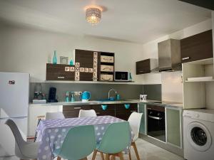 a kitchen with a table and chairs in a kitchen at Snowqueen Hotel Apartment Paris-Disney in Chelles