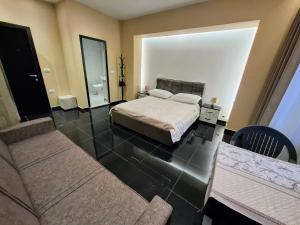 1 dormitorio con cama y sofá en CityCenterHotel Shkoder, en Shkodër