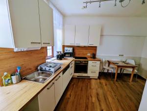 cocina con armarios blancos, fregadero y mesa en Wohnung im Zentrum von Graz, en Graz