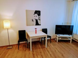 salon ze stołem, krzesłami i telewizorem w obiekcie Wohnung im Zentrum von Graz w Grazu