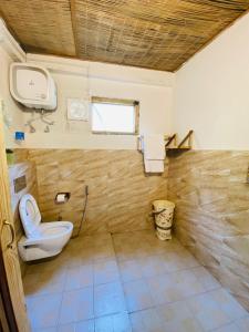 La salle de bains est pourvue de toilettes et d'une fenêtre. dans l'établissement Living Good - A Himalayan Boutique Stay, à Gushaini