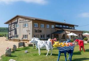 een groep nepkoeien voor een gebouw bij Dome Meadows 4 At Tapnell Farm in Yarmouth