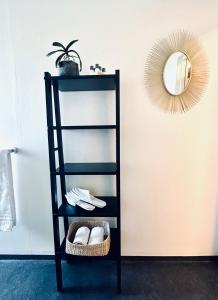 a black shelf with a mirror and a basket at SAGA, badehotell med sauna og badebrygge - Inderøy in Straumen