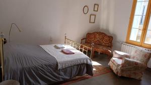 a bedroom with a bed and a chair at La Taniere 16 couchages in Vergèze