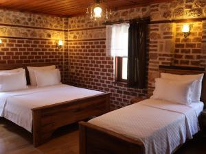 a bedroom with two beds and a brick wall at Casa Franco in Antalya
