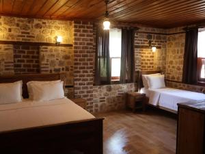een slaapkamer met 2 bedden en een bakstenen muur bij Casa Franco in Antalya