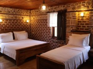 a bedroom with two beds and a brick wall at Casa Franco in Antalya