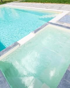 a swimming pool with blue water in a yard at Il Gattino di Porto - apt 5 - Bilocale terrazzo piscina in Imperia
