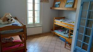 a small room with two bunk beds and a window at La Taniere 16 couchages in Vergèze