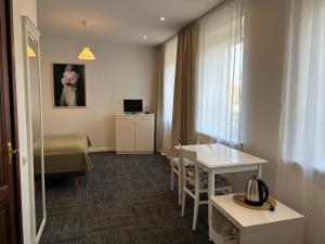 a room with a bed and a table and a window at Seven Sisters Apartments with Self Check-In in Liepāja