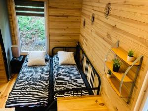 een kamer met 2 bedden in een tiny house bij Woody Lodge - Duplex Nature Bonsoy Ardennes in Hastière-par-delà +39 foto's