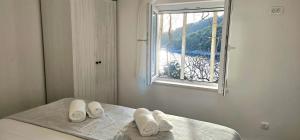 a bedroom with a bed with white towels on it at Holiday house Stela in Gdinj