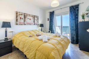 duże żółte łóżko w pokoju z oknem w obiekcie Puerta Del Mar Penthouse Beachfront - Happy Rentals w mieście Mijas Costa