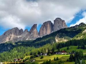 a valley in the mountains with houses and trees at Campitello House in Campitello di Fassa