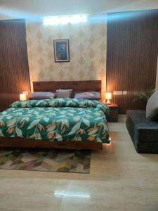リシケーシュにあるBlue Heart Home~1BHK Luxury & Cosy Flat in Tapovanの大きなベッドとソファのある寝室