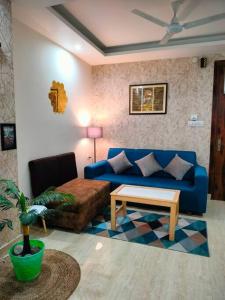 リシケーシュにあるBlue Heart Home~1BHK Luxury & Cosy Flat in Tapovanの青いソファとテーブルのあるリビングルーム