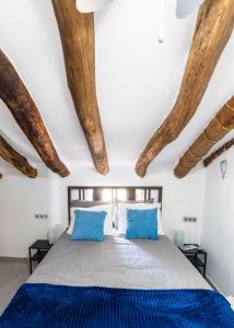 una camera da letto con letto, cuscini blu e travi in legno di Self-catering apartment with pool & hot tub in Oria a Oria