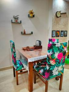 リシケーシュにあるBlue Heart Home~1BHK Luxury & Cosy Flat in Tapovanのダイニングルームテーブル(椅子2脚、テーブル付)
