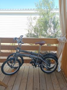 Una bicicleta está estacionada en una plataforma de madera. en Lado Mobile Home Croatia, Camp Oaza Lučica, Drage, en Drage
