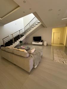 uma sala de estar com um sofá e uma escada em فيلا دورين ومنطقة مخصصة للقهوة em Buraydah