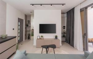 Gorgeous Home In Bilice With Wifi في بيليس: غرفة معيشة مع تلفزيون على الحائط