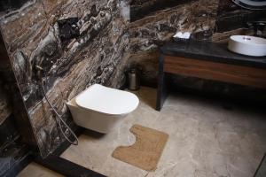 a bathroom with a toilet and a sink at Pink Villa Boutique Hotel in Meerut +33 photos