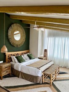 a bedroom with a bed and a chair and a mirror at Botanico Beauty Villa del Mar in Jávea
