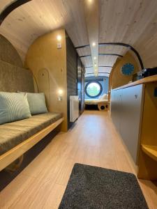 uma sala de estar com um sofá numa pequena casa em Celtic Minor Pods em Ystalyfera