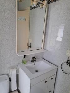 ein Badezimmer mit einem weißen Waschbecken und einem Spiegel in der Unterkunft Mar Blau in Mareny Blau