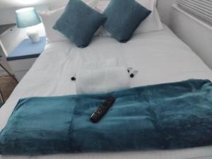 un mando a distancia sentado sobre una cama en Casa Brillo, en Londres