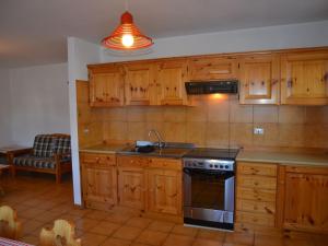 uma cozinha com armários de madeira e um forno com placa de fogão em Amazing Apartment in Cavalese with Shared Terrace em Cavalese