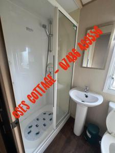 a bathroom with a shower and a sink at Ose's Cottage in Banks