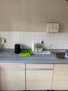 a kitchen counter with a dish drying rack and a sink at Warszawa Zachodnia in Warsaw