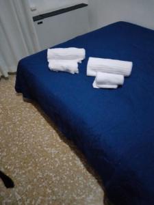 un letto blu con sopra asciugamani di Hotel Lombardia a Seveso