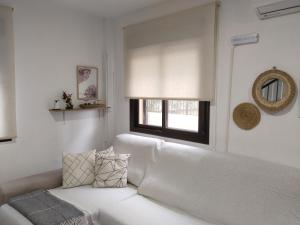 un sofá blanco en una sala de estar con ventana en Casa de la Aldea 